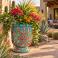 Hand-painted Mexican Talavera planter (TCTP560) with green foliage and flowering plants.