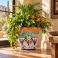 Hand-painted Mexican Talavera planter (TP430) with green foliage and flowering plants.