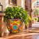 Colorful medium Mexican Talavera planter (TP250B) planted shown with leafy green plants.